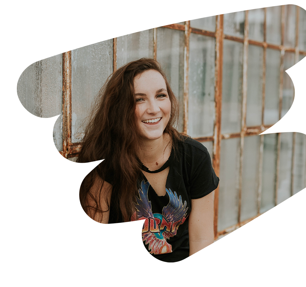 Portrait of a young woman with brown hair smiling.